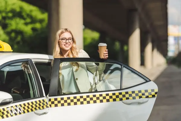 blondynka otwierająca drzwi do taksówki